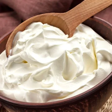 Requeijão cremoso numa tigela com colher de pau